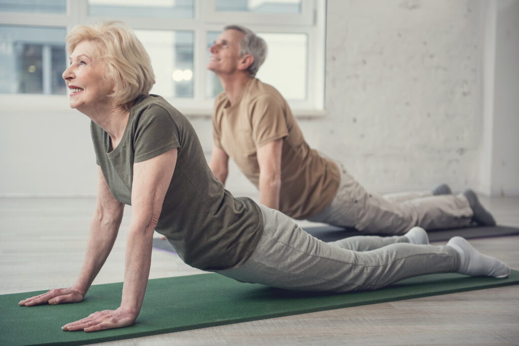 Yüksek motivasyonla yoga egzersizi yapan yaşlı çift